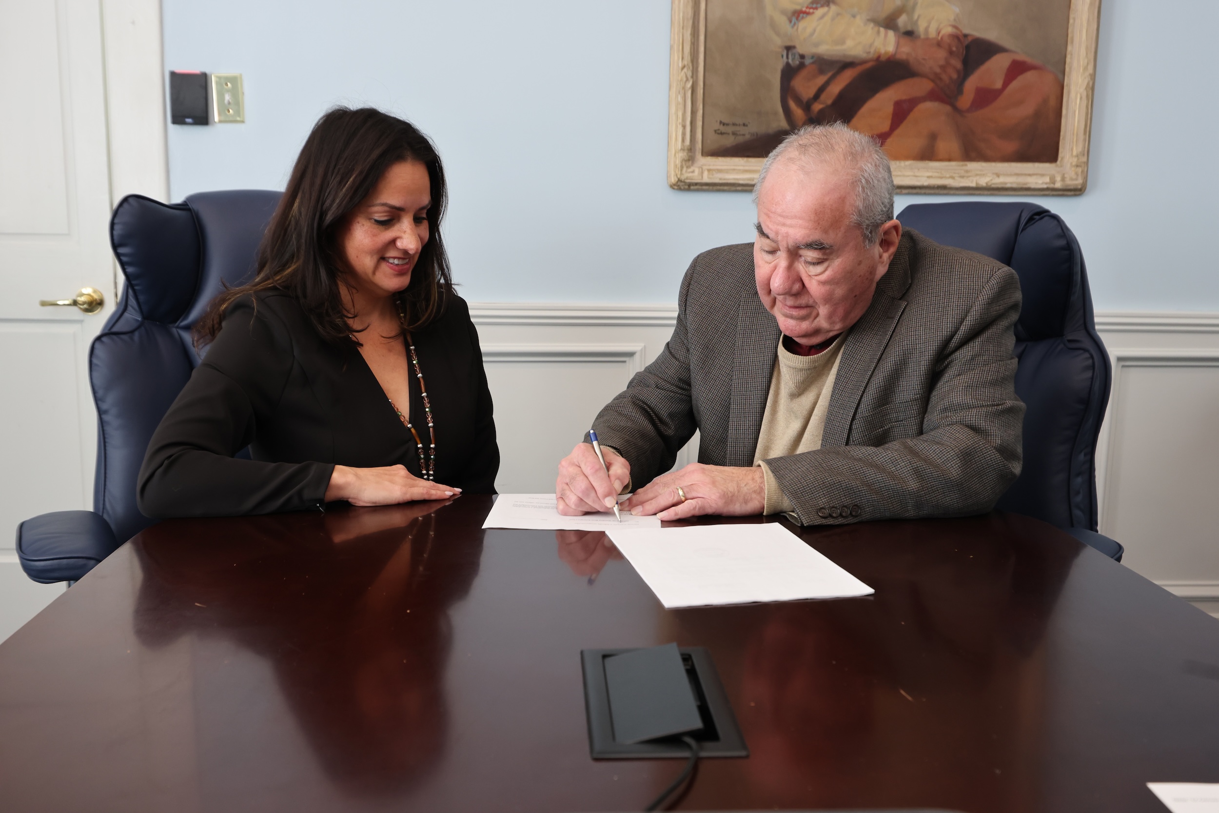 Osage Casino &amp; Hotel CEO Kimberly Pearson (left) presents two agreements with the City of Lake Ozark for Osage Nation Principal Chief Geoffrey Standing Bear’s signature.