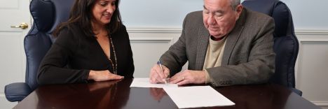 Osage Casino &amp; Hotel CEO Kimberly Pearson (left) presents two agreements with the City of Lake Ozark for Osage Nation Principal Chief Geoffrey Standing Bear’s signature.